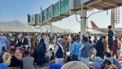 喀布尔国际机场的停机坪涌入大批民众，期望能尽快离开阿富汗。（图取自法新社）