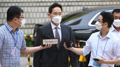 三星电子副会长李在镕，周四抵达首尔中央地方法院，就三星两家子公司有争议的并购案出庭受审，闻风而至的记者趋前访问他。（图取自法新社）