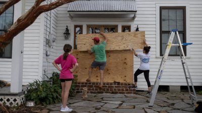 路易斯安那州新奥尔良市民加紧做防灾准备，有人在家门外用木板加固，以减低风暴袭击的损毁程度。（图取自路透社）