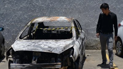 2016年希腊驻巴西大使阿米里迪斯焦尸案，法院当地时间周日裁定，死者的巴西籍妻弗朗索瓦丝谋杀亲夫，判处监禁31年。图为当年12月30日，一名男子看著阿米里迪斯已遭焚毁的出租汽车，而在当月29日，警方在该汽车内发现阿米里迪斯的焦尸。（法新社档案照）