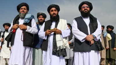 阿富汗塔利班发言人穆贾希德（中）周二在喀布尔国际机场向媒体讲话，而在此前一天美国撤出阿富汗，结束长达20年的战争。（图取自法新社）
