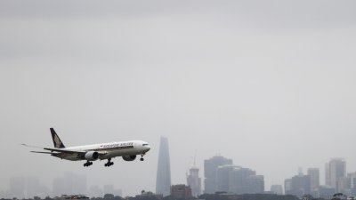 澳洲重新开放边界，却遇上新变种毒株Omicron搅局。图为一架新加坡航空的班机，在周二抵达悉尼机场。（图取自路透社）