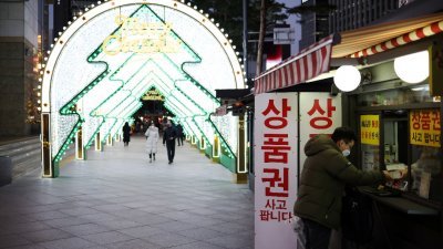 圣诞节将至，韩国首尔市已经架起应节装饰，但街上行人寥寥无几。（图取自路透社）