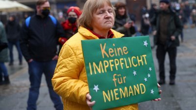 上周六，在德国法兰克福市区，有一批示威者举行集会抗议政府推行防范新冠疫情爆发的措施，其中一名示威者举著标语，上面写著“别强制所有人接种疫苗”。（图取自路透社）