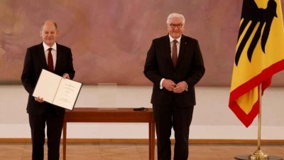 在柏林贝总统府举行的仪式上，新当选的德国总理肖尔茨（左）获得了总统施泰因迈尔的任命证书。（图取自法新社）