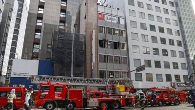 大阪消防局接获投报后，赶到失火的楼宇，并迅速将火势扑灭。（图取自共同社/路透社）
