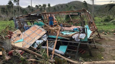 超级台风“雷伊”上周四（16日）肆虐菲律宾中南部，各地急需民生物资救援。图为菲国南部锡亚高岛达帕镇的村庄，居民周三站在遭“雷伊”摧毁的房屋残骸上。（图取自法新社）