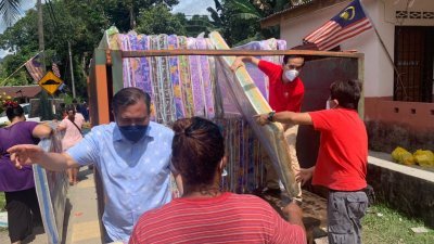 明吉摩办公室团队将100张床褥抬上罗里，准备送往森州，派发给甘榜二南吉打原住民村灾黎。