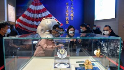 “嫦娥五号”备份存储月球样品交接仪式周六在湖南省韶山市举行，中国国家航天局提供的公益展示月球样品也在韶山展出。图为民众参观月球样品。（图取自中新社）