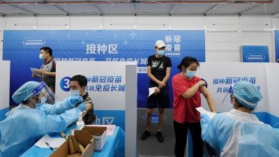 中国国家卫生健康委员会宣布，截至周六，中国已有超过12亿人完成新冠肺炎疫苗全程接种。图为居民在广东省省会广州的临时疫苗接种点，接受施打新冠疫苗。（图源自中新社）