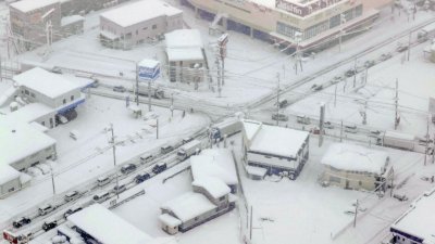 日本滋贺县彦根市有车阵滞留在大雪中。（图取自路透社）