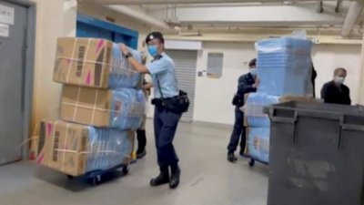 香港警方周三早突击搜查《立场新闻》的办公室，警方人员带了大批箱子准备搜证。（图取自路透社）
