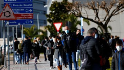 在西班牙首都马德里，当地民众在圣诞假期过后的周一排队等待进行新冠肺炎病毒检测。（图取自路透社）