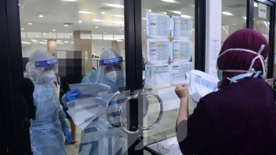 一门玻璃隔间隔离病房内外，在病房内的医护人员，透过对讲机与同事进行工作上安排。