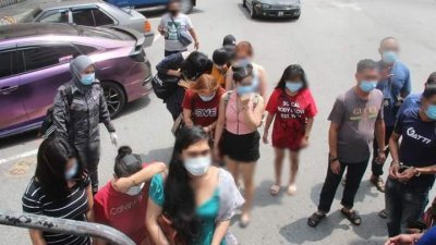 马六甲移民局执法人员将被捕的外籍女子带上车。