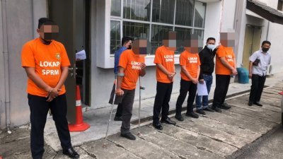 5名陆交局男官员遭到逮捕后，等候前往反贪会扣留所。