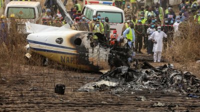 飞机坠毁后著火烧成废铁，机上7人全数丧命。救援人员封锁坠毁地区进行调查。-路透社-