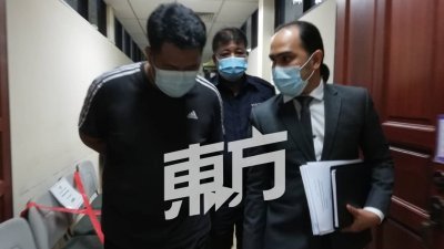 被告（左）被庭警押往扣留室途中，与代表律师讨论案情。（摄影：赵玉花）