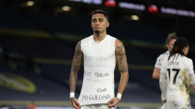 巴西边锋拉菲尼亚（图）操刀自由球直接破门后，脱下球衣露出T恤上的字，向上周六因冠病病逝的罗纳迪尼奥母亲多娜致敬。