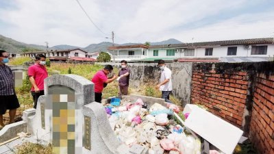 周锦欢（左4）和团队成员检查坟墓上的垃圾堆。（图取自面子书）