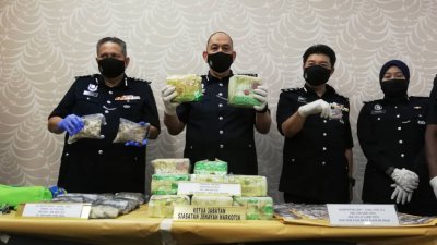 米尔法立达拉（左2）向媒体展示霹雳州警方通过3项行动所起获的各类毒品。左3为李庆泉。