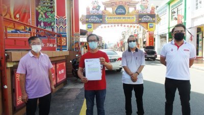 刘志俍（左2）出示甲市政厅执照组的回函，促马六甲鸡场街文化坊工委会响应地方政府的号召，左起为陈劲源、李祥生和梁恩来。