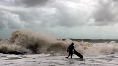 一名冲浪爱好者无视气候警报在遮拉丁海滩（Cherating）风高浪急之时进行水上活动。（马新社）