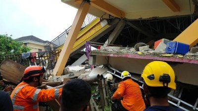 印尼西苏拉威西省周五凌晨发生里特制6.2级地震，至少7人罹难、600多人受伤。搜救人员在该省首府马穆朱的一处倒塌建筑挖掘废墟，以拯救受困人士。（路透社）