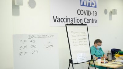 据统计，英国英格兰目前约有446万名病患需要非紧急手术，只能继续排队等待。这是英格兰斯蒂大尼奇镇罗伯逊大厦的NHS疫苗接种中心，布告栏当地时间周四显示周一至周三的新冠肺炎疫苗接种量。（图取自路透社）