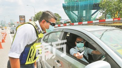 八打灵再也警区主任聂依查尼助理总监在西部疏散大道 （SPRINT）往新巴生谷高速大道（NKVE）的收费站前，检查路过的车辆。（摄影：连国强）