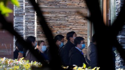 中国科学家周五上午来到世卫国际专家组接受隔离的酒店，双方首次举行面对面会谈。专家组在过去两周隔离期间，一直跟中方专家进行视像会议。（图取自路透社）