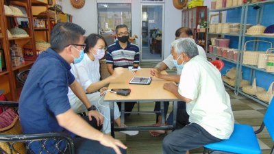 陈家兴（左）与霹雳残障人士协会理事们商讨销售藤制品转型计划。