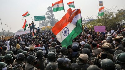 印度农民抗议新农业法的示威在经过两个月后转为紧张，在上周五有反农民抗议的人士试图闯入农民抗议的聚集地时，遭到警员们的阻止，前者挥舞著印度国旗和大喊反农民口号，要警员们让开。（照片：路透社）
