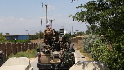 阿富汗首都喀布尔以北约70公里处，美国和北约部队全数离开后，阿富汗国民军（ANA）士兵周五在巴格拉姆空军基地外的公路检查站的车辆后面站岗。 （图取自法新社）