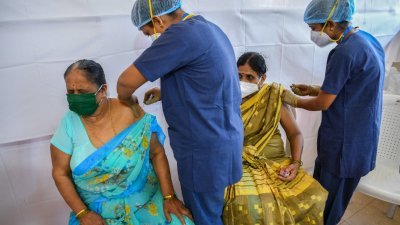 印度金融城市孟买传出有不肖人士大赚黑心钱，让数以千计公众接种到生理食盐水灌充的假新冠肺炎疫苗。图为医务人员周日在孟买，为民众接种Covishield疫苗，也就是印度所代工的英国阿斯利康（AstraZeneca）疫苗。（图取自法新社）