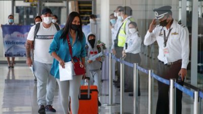 普吉岛上周四解封当天，迎来的首批观光客包括来自阿联酋阿布扎比的游客。机场上的移民官对抵达的游客敬礼。（图取自路透社）