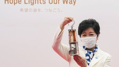 奥运圣火周五抵达东京，东京都知事小池百合子在欢迎仪式上举起圣火。（图取自路透社）