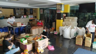 906酒店的大厅充作临时物资分配中心，陈江荣的家人和员工都加入援助行列。