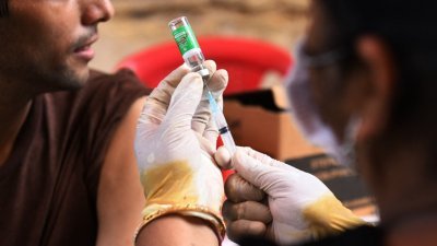 印度旁遮普邦阿姆利则市的一个疫苗接种营中，医务人员上周五准备为一名学生施打一剂预防新冠肺炎的Covishield疫苗，也就是该国生产的英国阿斯利康（AstraZeneca）疫苗。（图取自法新社）