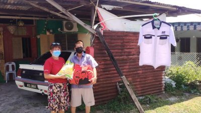 行动党双溪古月新村协调员李宝兰（左）接获马华党员挂国阵白衣求助的消息后，立即给对方送上乾粮福袋。