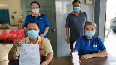 郑顺和（前左）展示警方报案书，控诉甘文丁疫苗接种中心为民众接种的方式违反了标准作业程序。前左2为洪瑞樱；后左起是李丽珺与黄协来。