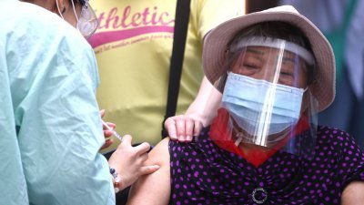 台湾民众在台北市的台湾科学教育馆，接种莫德纳疫苗。（图取自路透社）
