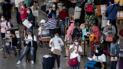 菲律宾大马尼拉地区帕赛市的尼诺·阿基诺国际机场，周二可见到多数戴著口罩的海外菲律宾劳工（Overseas Filipino Worker, OFW），在离境区排队。 （图取自路透社）


