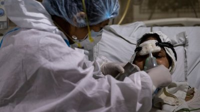 印度疫情趋缓，图为一名医务人员照顾确诊染疫的病人。