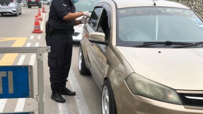 警方设立路障检查每一辆途径车辆，以严防民众擅自跨州。