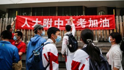 今年6月7日在中国北京，学生们竖起横幅为参加一年一度的全国高考（大学入学考试）的考生加油助威。（图取自路透社）