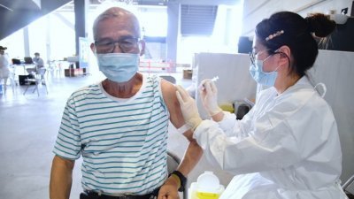 台湾年长民众周六前往台北市网球中心接种站，施打新冠疫苗。（图取自中央社）