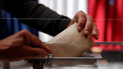 在法国勒图凯-巴黎普拉日举行的第一轮法国地方选举投票，选民将选票投进票箱。（图取自路透社）