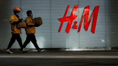 根据美国《华尔街日报》，在瑞典服装品牌H&M因为有关新疆的言论遭中国消费者抵制后，多个国际服装集团一度撤回相关声明，但部分集团之后重申批评立场。图为中国首都北京的一家购物中心外，民众经过H&M门市。 （路透社档案照）