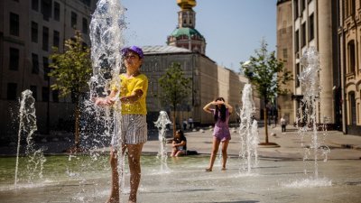 莫斯科遭到热浪侵袭出现百年高温，民众到喷水池戏水解暑。（图取自法新社）